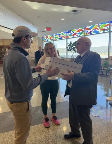 Rep. Bresnahan (left) and wife, Chelsea Strub, deliver pizzas to AVP officials and TSA agents.