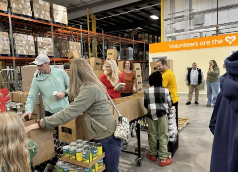 Rep. Bresnahan, Chelsea, and other volunteers pack boxes at Food Bank